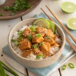 “Bang Bang Chicken Bowl with creamy spicy sauce over jasmine rice in a white bowl”