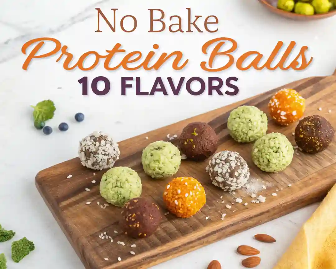 Colorful assortment of no bake protein balls in different flavors on a wooden board.