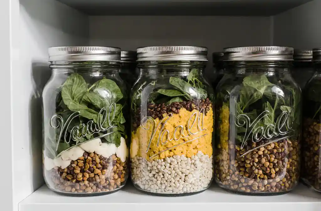 Glass jars of vegan tofu scramble with lentils and greens
