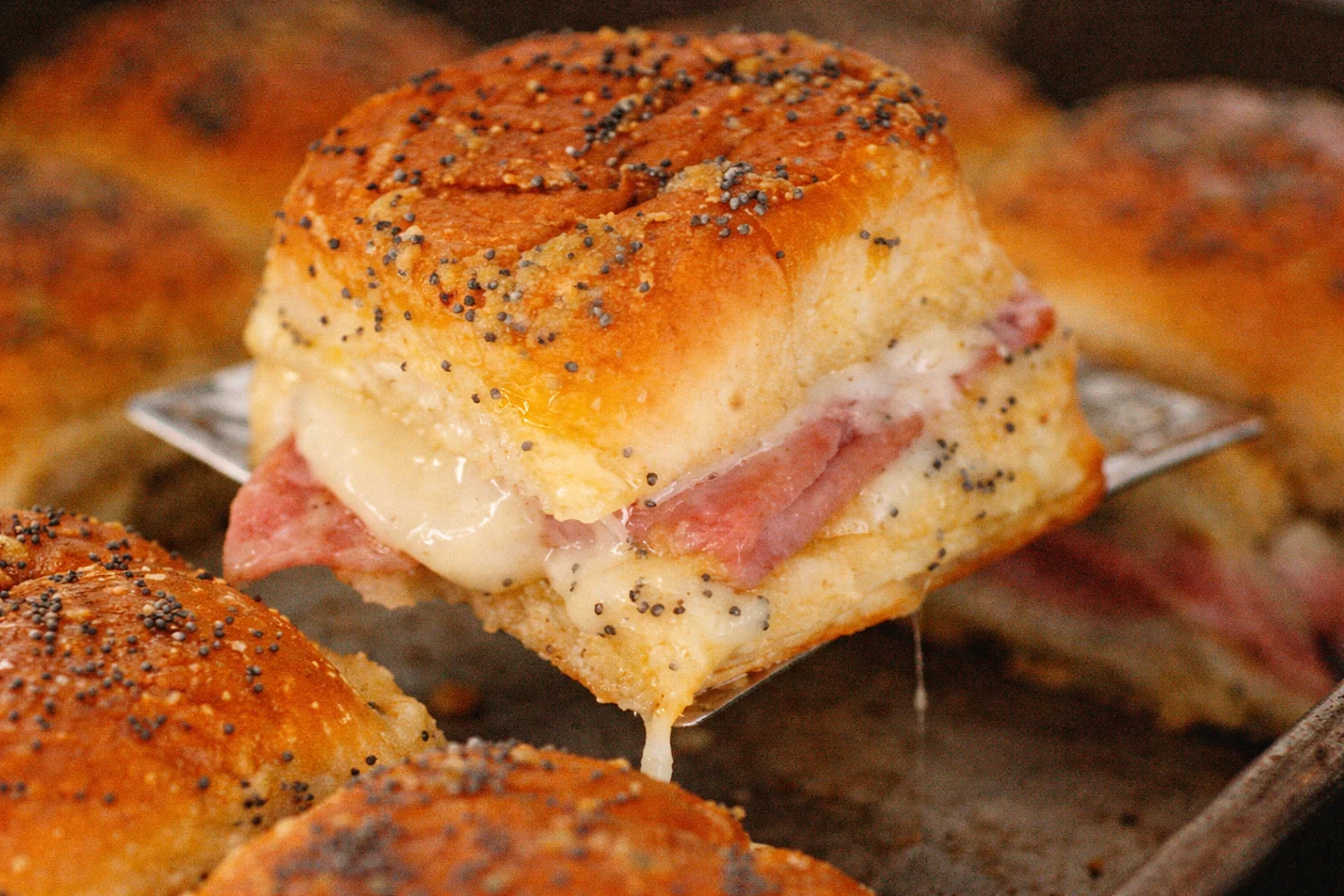 Ham and cheese sliders served on a platter with toppings