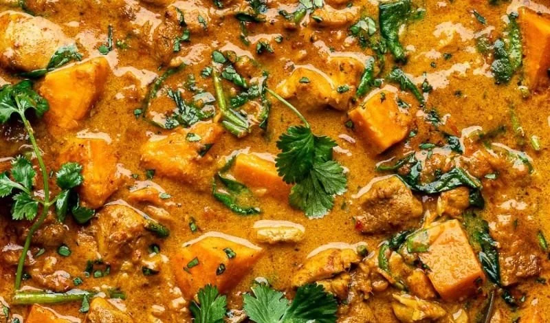 Chicken Sweet Potato Curry served in a bowl with herbs and spices